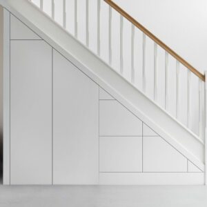 Custom under stairs storage with three drawers and a tall cupboard, designed for modern homes.