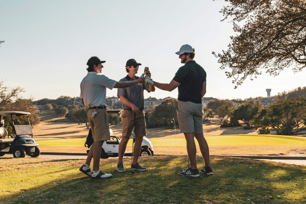 Three golfers celebrating on the course with drinks after a round of golf Air Caddy