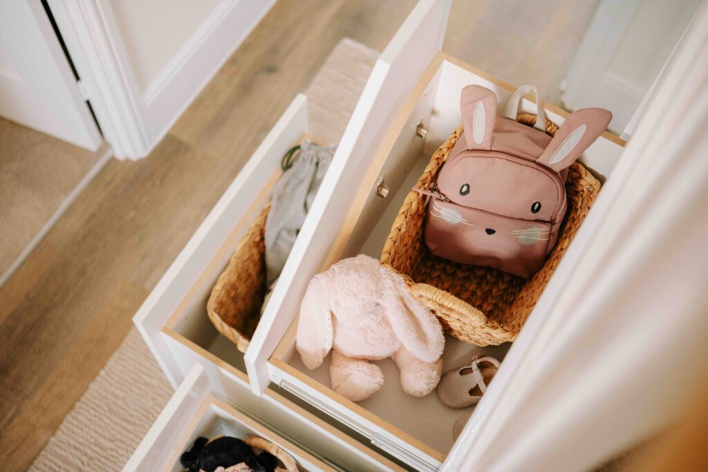 Under stairs storage drawer filled with children’s toys and baskets